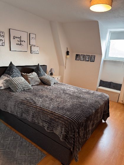 Schlafzimmer mit Spiegel-Kleiderschrank, Doppelbett und Babybett