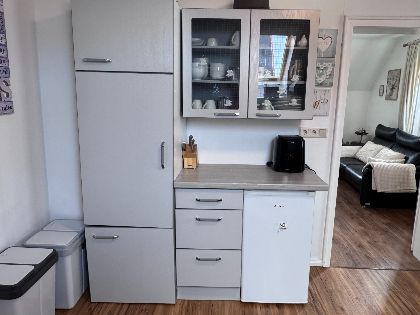 Küche mit grauen Schränken und Kühlschrank